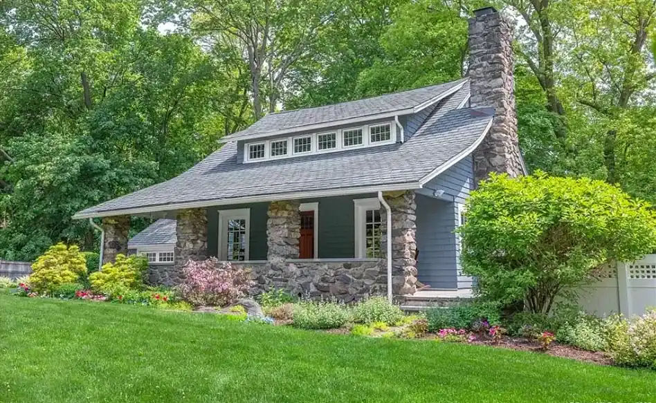 Shingled home with a stone chimney after exterior painting