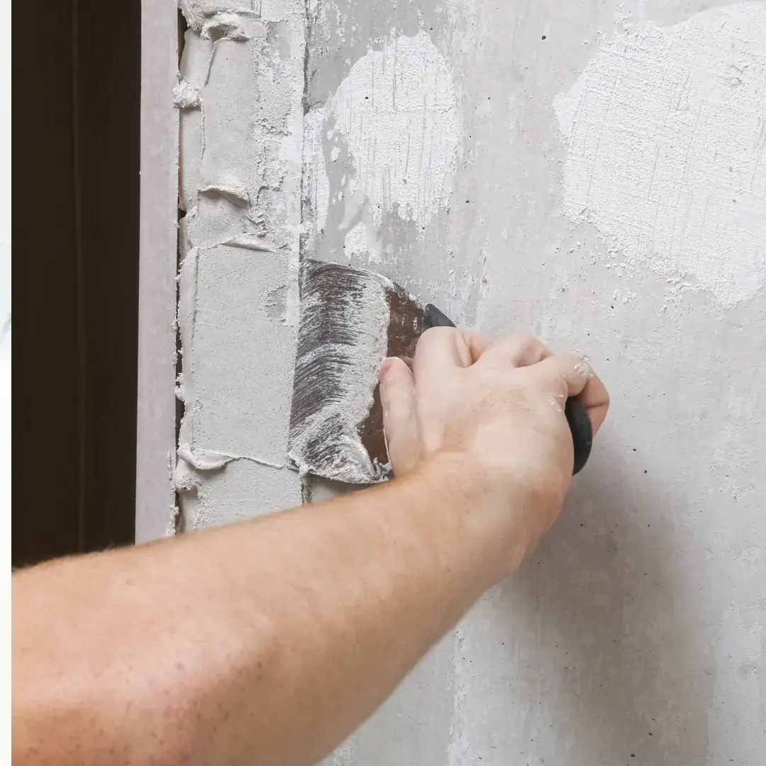 Painter skim-coating a wall as part of a drywall repair