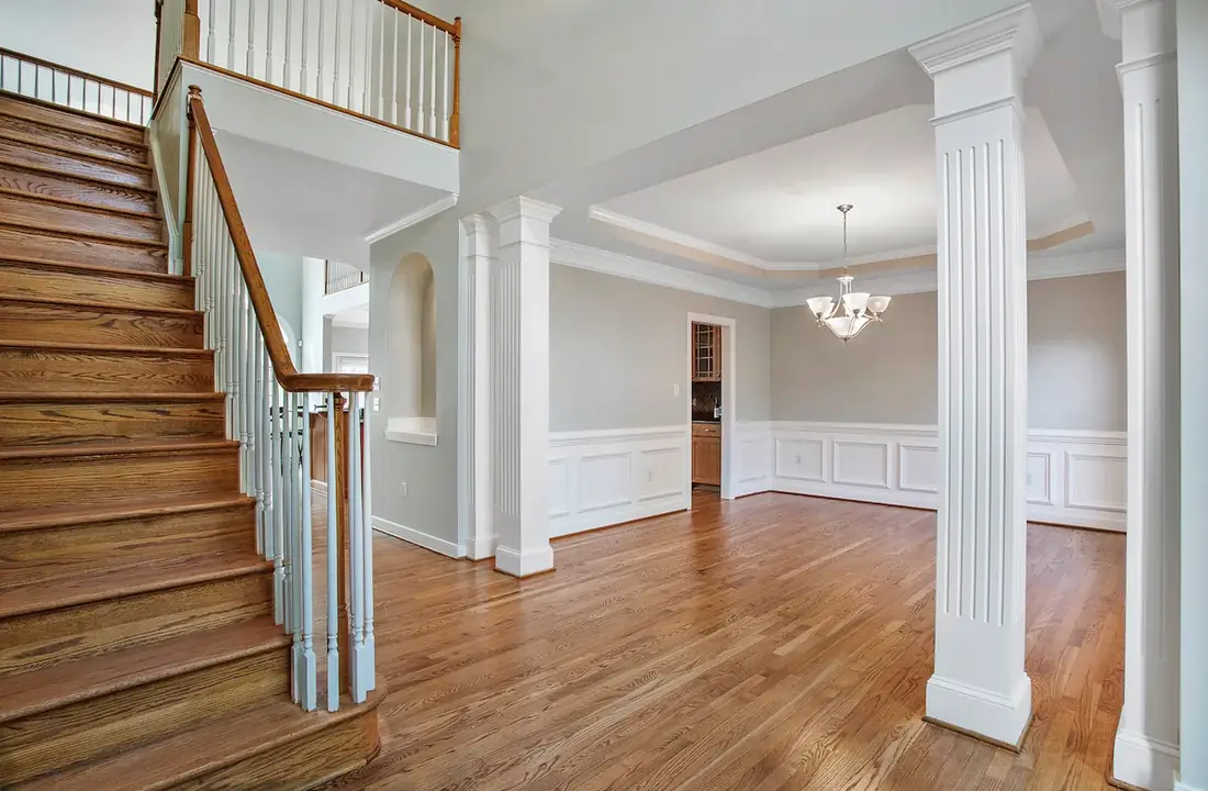 Entry hall and staircase with white wainscoting and trim